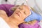 Woman in cosmetic hat receiving darsonvalization facial treatment