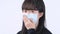 Woman coughing with mask - young Asian covering the mouth, feeling unwell with wearing medical blue face mask isolated on white
