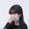 Woman coughing with mask - young Asian covering the mouth, feeling unwell with wearing medical blue face mask isolated on white