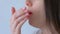 Woman coughs on white background during coronavirus quarantine, face closeup.