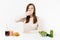 Woman cover mouth with hand with green detox smoothies, salad in glass bowl, cucumber, burger, cola in bottle isolated