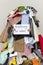 Woman covered with pile of different cloth holding Nothing to wear table sign