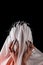 A woman covered with white cloth with a closed face suffers. faceless pain. long black nails on thin female fingers. emotion