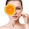 Woman covering eye by orange slice.