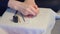 Woman is covering nails applying grey shellac gel polish at home, hands closeup.