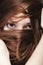 Woman covers the face by long brown hairs