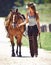 Woman, cowgirl and walking with horse in the countryside for outdoor ride on the farm in nature. Female person or