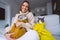 Woman in cozy sweater with her cats feeling cold and warming under a blankets