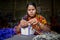 A woman crafts maker is making a showpiece home from the fibers of a banana tree at Madhupur, Tangail