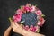 Woman creates a bouquet of blueberries and pink flowers in a circle