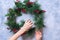 Woman Creates Green Christmas Decorative Wreath