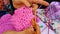 Woman crocheting a pink girl dress with wool and hook.close up shot of professional crocheting woman