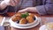 Woman in cropped view eating salted cod food, Pasteis de Bacalhau, Bacalao, Bacallao, delicious Portuguese dishes meal in Macau re