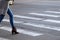 Woman crosses the road on pedestrian crossing. Motion blur.