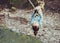 Woman crossing a river with tyrolean traverse