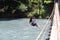 Woman crossing a river with tyrolean traverse