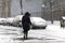 Woman crossing street during snow storm