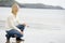 Woman crouching on beach