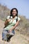 Woman crouching on beach path smiling