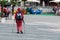 A woman with crutches and a backpack goes along the sidewalk. View from the back