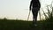 A woman on crutches walks on the grass outside the city. Leisure. Rehabilitation after a broken leg