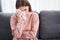 Woman crying alone while sitting on couch