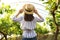 Woman among cultivated grape plants in greenhouse