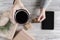 Woman with cup of coffee, credit card and tablet. Packing gifts. Cardboard box in craft paper on the rustic wood planks background