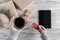 Woman with cup of coffee, credit card and tablet. Packing gifts. Cardboard box in craft paper on the rustic wood planks background