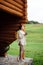 Woman with cup of coffee standing on terrace of wooden house