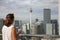 Woman with a cup of coffee on the top floor of a skyscraper admires the view of Kuala Lumpur.