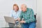 Woman and curious senior with tablet computer