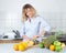 Woman with curly blond hair preparing orang juice in the kitchen