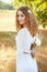 Woman with curly golden hair smiling standing in the field