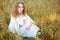 Woman with curly golden hair smiling standing in the field