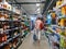 Woman customer inside large interior supermarket buy alcoholic products