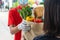 Woman customer receiving fresh food set bag from food delivery service man wearing protection glove and face mask