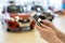 Woman customer uses a mobile smartphone in a dealer showroom. Modern lifestyle