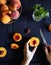 Woman cut fresh peaches on the wooden table