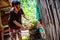 Woman cut a top of coconut in her house to sell refreshing coconut milk to tourists