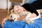 Woman with cute dogs at home. Handsome girl resting and sleeping with her dog in bed in bedroom. Owner and dog sleeping in sofa.