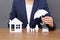 Woman with cutout paper family, house, car and umbrella at table, closeup.