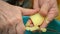 A woman cuts boiled potatoes into pieces for salad