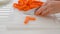 Woman cuts carrot. Fresh organic peeled baby carrots close up on cutting board