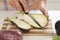 Woman cuts eggplant on cutting board in kitchen.