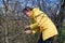 A woman cuts extra and thin branches on an apple tree with a hand saw