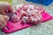 Woman cuts fresh animal meat on pink plastic board