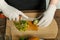 Woman cuts a knife on a wooden kiwi plate into pieces.