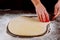Woman cuts out dough circles for making buns, dounuts