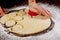 Woman cuts out dough with round mold for making buns, dounuts